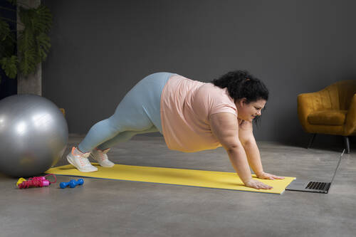Full shot woman exercising gym